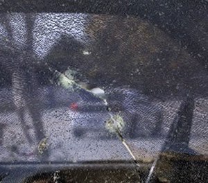 A car is seen through the window of a pickup truck shattered by bullets fired during a police shootout with San Bernardino shooting rampage suspects Syed Farook and his wife, Tashfeen Malik, Saturday, Dec. 5, 2015, in San Bernardino, Calif.