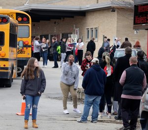 Waukesha South High School students find their waiting parents and friends and hug after they leave the building following shots fired inside the school.