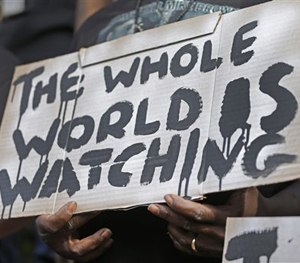 A man holds a sign during a protest for the shooting death of Walter Scott at city hall in North Charleston, S.C., Wednesday, April 8, 2015. (AP Image)