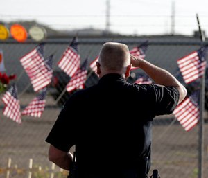George Murphy of the Yavapi Tribal Police pays his respects at a makeshift memorial outside the Granite Mountain Interagency Hotshot Crew fire station, Tuesday, July 2, 2013, in Prescott, Ariz., honoring 19 firefighters killed battling a wildfire near Yarnell, Ariz. (AP Photo/Chris Carlson)