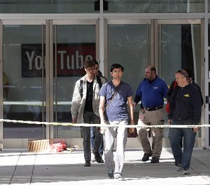 A group walks out of a YouTube office building in San Bruno, Calif., Wednesday, April 4, 2018.