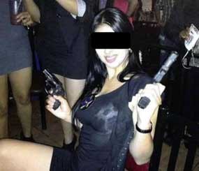 Prosecutors handling a case involving about 200 official-looking badges given to politicians released a photo of a woman in a nightclub holding two handguns and wearing a badge given to a councilman.