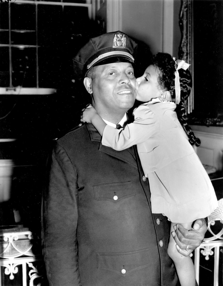 In this Sept. 4, 1941 file photo, Lt. Samuel Battle gets a kiss from his 4-year-old granddaughter, Yvonne, at City Hall in New York where he was sworn in as the first black parole commissioner in the city.