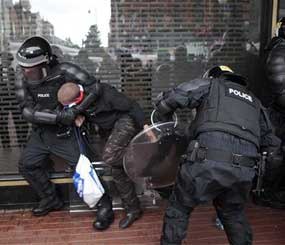A loyalist is arrested by riot police in the center of Belfast Northern Ireland, Friday, Aug. 9. (AP Image)