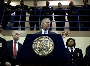 Surrounded by corrections officers, New York City Mayor Bill de Blasio holds a news conference on Rikers Island in New York, Thursday, March 12, 2015. The mayor has unveiled a comprehensive plan to curb jail violence after a visit to the problem-plagued Rikers Island jail complex.