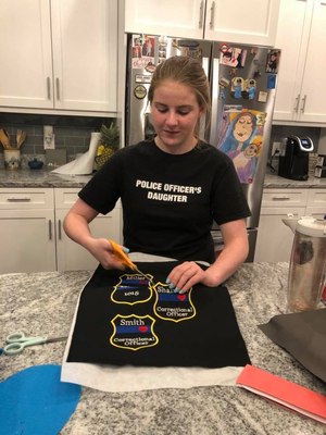 In this photo, Megan cuts out custom shields that include the last name and badge number of each officer. (Photo/Blue Line Bears)