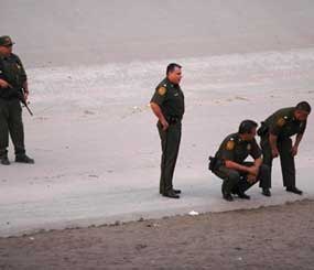 U.S. border patrol agents examine the area near where 14-year-old Mexican youth Sergio Adrian Hernandez Huereca was killed, allegedly shot by a U.S. Border Patrol agent after a confrontation under the Paso Del Norte border bridge in Ciudad Juarez. (AP Image)