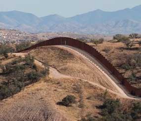 This file photo shows the border fence stretching west of Nogales, Ariz. into the Coronado National Forest. An Arizona lawmaker, Republican state Sen. Steve Smith, who is leading an effort to build additional fences near the state's border with Mexico through donations said he expects to begin construction on more barriers some time next year.