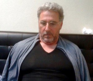 In this photo taken on Sunday, Sept. 3, 2017, a man identified by Italian Police as longtime fugitive Rocco Morabito looks down after being arrested in a Montevideo hotel, Uruguay. (Italian Police via AP)