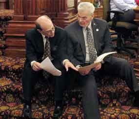 In this photo Kansas state Reps. Steve Brunk, left, a Wichita Republican, and Arlen Siegfreid, right, an Olathe Republican, confer during a Statehouse debate in Topeka, Kan., prior to passage of the Second Amendment Protection Act.