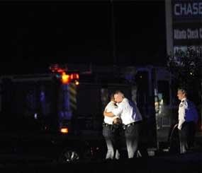 Law enforcement personnel embrace early Sunday, Nov. 4, 2012, as others investigate the scene of an Atlanta Police Department helicopter crash that killed two officers aboard the aircraft when it crashed near a shopping center late Saturday, Nov. 3, 2012.