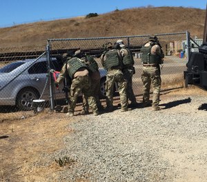 Tactical officers breach a gate at the start of a training exercise.
