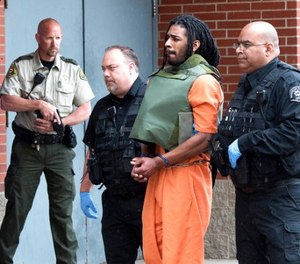 In this May 10, 2017, file photo, Wesley Correa-Carmenaty is led into the Woodbury County Jail in Sioux City, Iowa. Prosecutors say the man charged with killing a sheriff's deputy and wounding another while escaping from an Iowa jail will plead guilty.