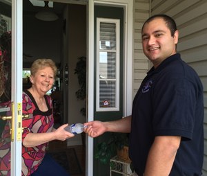 Paramedic Brendon Firooz shares a bottle of water with Mary Reese after discussing the risks of summer heat and humidity. (Image courtesy SCCAD)