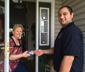 Paramedic Brendon Firooz shares a bottle of water with Mary Reese after discussing the risks of summer heat and humidity. (Image courtesy SCCAD)
