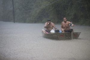 Image: A pair of men get into a boat to float in to rescue a family trapped by floodwaters as rain from Tropical Depression Imelda inundated the area on Thursday, Sept. 19, 2019, near Patton Village, Texas.