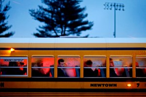 People arrive on a school bus at Newtown High School for a memorial vigil attended by President Barack Obama for the victims of the Sandy Hook Elementary School shooting in Newtown, Conn.