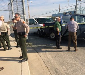 This image provided by Ray Pruitt with the Kern County Sheriffs Office shows officers looking at a pickup truck after a white prison van crashed into it at the gates of the Lerdo Pre-Trial Facility near Bakersfield, Calif., on Weds., March 2, 2016.