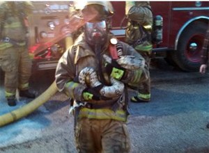 Firefighter Scott Hemmelsbach said that he reluctantly agreed to enter the two-story, smoke-filled house to retrieve the snake. He says he cradled the "weighty" snake before carrying it to safety. (AP Photo/Courtesy of Gordon Cole)