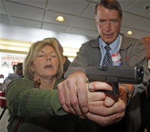 Christine Caldwell, left, receives firearms training with a 9mm Glock from personal defense instructor Jim McCarthy during concealed weapons training for 200 Utah teachers.