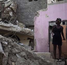 A woman stands on the remains of her home, damaged by the Jan. 12 earthquake, in Port-au-Prince, Haiti. (AP Photo/Ramon Espinosa)