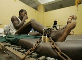 An inmate is padlocked to a bed in the emergency room of the General Hospital of Port-au-Prince, Haiti. (AP Photo/Ariana Cubillos)