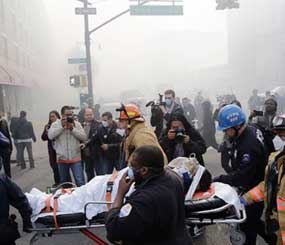 Rescue workers remove an injured person on a stretcher after a possible explosion and building collapse in the East Harlem neighborhood of New York, Wednesday.