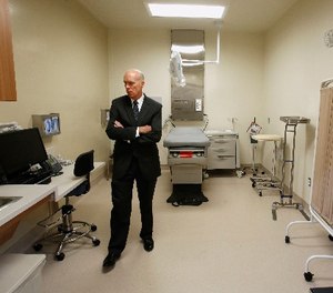 In this June 25, 2013 file photo , David Culberson, chief executive officer of San Joaquin General Hospital, looks over one of the patient care rooms while touring the new California Correctional Health Care Facility in Stockton, Calif.