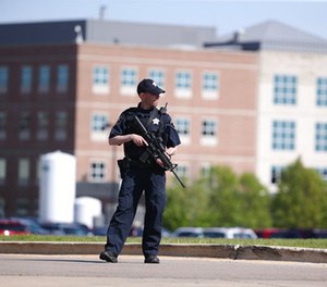 A Kane County police officer monitors the scene at Northwestern Medicine Delnor Hospital in Geneva, Ill., during a lockdown after a jail inmate being treated there managed to take a correctional officer's gun in the facility and hold an employee hostage, Saturday, May 13, 2017.