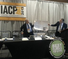 At left, Dr. Leigh Altadonna, Assistant Superintendent of Abington Schools, helps Chief Bill Kelly of the Abington (Pa.) Police Department show attendees an example of the large, laminated floor plans, pictures of the schools, and other tactical information stored in tubes in the trunks of all Abington PD squad cars. (PoliceOne Image)