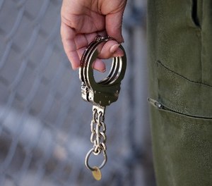 A CO holds a pair of handcuffs at San Quentin State Prison Tuesday, Aug. 16, 2016, in San Quentin, Calif. (AP Photo/Eric Risberg)