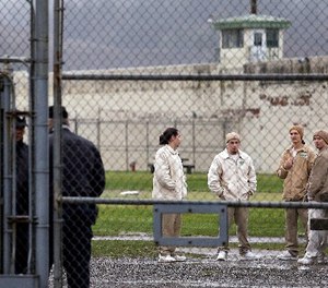 In this file photo taken Jan. 28, 2016, inmates mingle in a recreation yard in view of COs, left, at the Monroe Correctional Complex in Monroe, Wash. (AP Photo/Elaine Thompson)