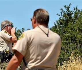 The Santa Barbara County Sheriff Officials Buddy Allain, left, and B. Collins, tell people to evacuate due to the La Brea Fire burning in the hills above Tepusquet Canyon Road East of Santa Maria, Calif. (AP Photo/Phil Klein)