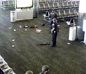 In this Nov. 1, 2013 file photo provided to the AP, which has been authenticated based on its contents and other AP reporting, police officers stand near a weapon at the Los Angeles International Airport after a gunman opened fire in the terminal, killing one person and wounding several others.