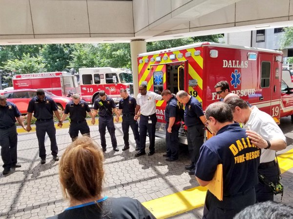 Dallas Fire-Rescue Chaplain Ray Schufford leading prayer for a safe drive home and seamless recovery for An. (Photo/Dallas Fire-Rescue via Twitter)