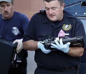 Investigators remove computer equipment as evidence from the apartment of alleged gunman James Holmes, Saturday, July 21, 2012 in Aurora, Colo. Authorities reported that 12 died and more than three dozen people were shot during an assault at a movie theatre midnight premiere of "The Dark Knight Rises." (AP Photo/Alex Brandon)