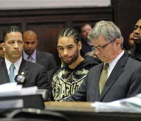 Luis Ortiz is arraigned in Brooklyn criminal court with his attorney Eric Poulos, right, in New York. Ortiz was arraigned on a charge of attempted murder of a police officer. He's accused of shooting Officer Kevin Brennan on Tuesday. (AP Image)