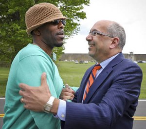 Calvin Buari, left, is embraced by his lawyer Oscar Michelen following his release from Green Haven correctional facility, shown in background, Monday May 8, 2017, in Stormville, N.Y. Buari, who spent 22 years in prison for a double killing he said he didn't do, was freed after his conviction was overturned.(AP Photo/Bebeto Matthews)