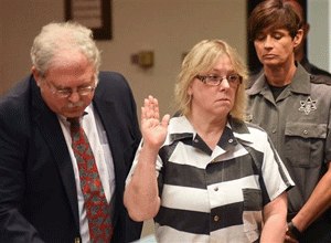 In this July 28, 2015 file photo, Joyce Mitchell raises her hand during a court appearance in Plattsburgh, N.Y. (Rob Fountain/The Press-Republican via AP, Pool, File)