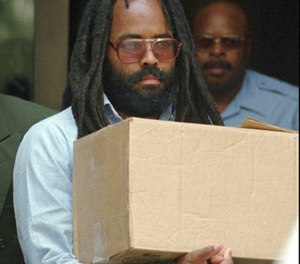 In this July 12, 1995, file photo, Mumia Abu-Jamal, a former Black Panther and radio reporter convicted of the 1981 murder of white Philadelphia police officer Daniel Faulkner, leaves after a hearing at City Hall in Philadelphia. (AP Photo/Chris Gardner, File)