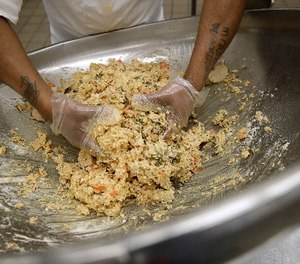 In this Jan. 10, 2017 photo, an inmate mixes ingredients to make a nutraloaf.