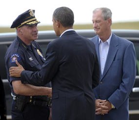 President Barack Obama greets Aurora (Colo.) Police Chief Daniel Oates, as Mayor Steve Hogan, right, watches after Obama arrived at at Buckley Air Force Base, Colo., Sunday, July 22, 2012. Obama is traveling to Aurora to visit with families of victims of the movie theater shooting as well as local officials.