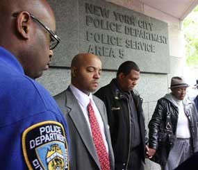 New York Police Department Community Affairs officer, left, Edwards Gibbs, founder of Harlem United Clergy for Change, second from left, and others gather Friday May 29, 2009 outside the police station where officer Omar J. Edwards worked in the East Harlem neighborhood of New York. Edwards, 25, who drew his gun while chasing someone he had found rummaging through his car, was shot and killed Thursday May 28 by a fellow officer who was driving by and saw the pursuit. (AP Photo/Tina Fineberg)