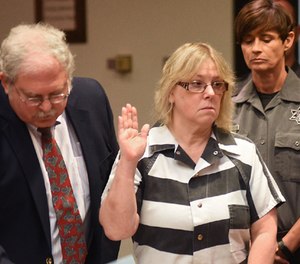In this July 28, 2015 file photo, Joyce Mitchell raises her hand during a court appearance in Plattsburgh, N.Y.