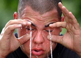 Georgia Air National Guard Senior Airman William B. Perez washes pepper spray out of his eyes during a training exercise in non-lethal tactics. (AP photo)