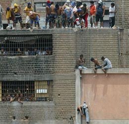 A group of prisoners lower the body of a dead inmate using a rope during a prison riot at the San Pedro Prison in Lima, Peru on Tuesday, Feb. 8, 2005. (AP photo)