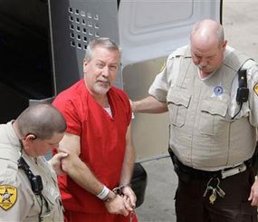 In this May 8, 2009 file photo, former Bolingbrook, Ill. police Sgt. Drew Peterson arrives at the Will County Courthouse in Joliet, Ill., for his arraignment on charges of first-degree murder in the 2004 death of his former wife Kathleen Savio.