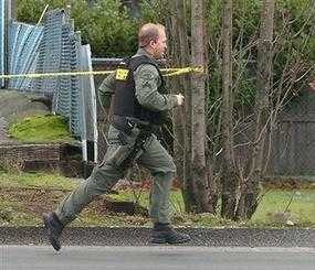 A Pierce County Sheriff deputy runs to the site where four police officers killed in an ambush at the Forza Coffee Co. near Parkland, Wash., on Sunday, November 29, 2009. Pierce County Sheriff's spokesman Ed Troyer told The News Tribune in Tacoma one or two gunmen burst into the Forza Coffee Co. and shot the four uniformed officers as they were working on their laptop computers, then fled the scene. (AP Photo)