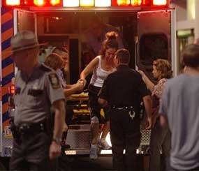 Emergency workers help a woman from the back of an ambulance after treating her in front of an LA Fitness location in Bridgeville, Pa. on Tuesday, Aug. 4, 2009. (AP Photo)
