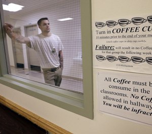 In this photo taken Thursday, Jan. 28, 2016, inmate Tim Booth leans against a wall during a break from his college world history class at the Monroe Correctional Complex in Monroe, Wash. (AP Photo/Elaine Thompson)